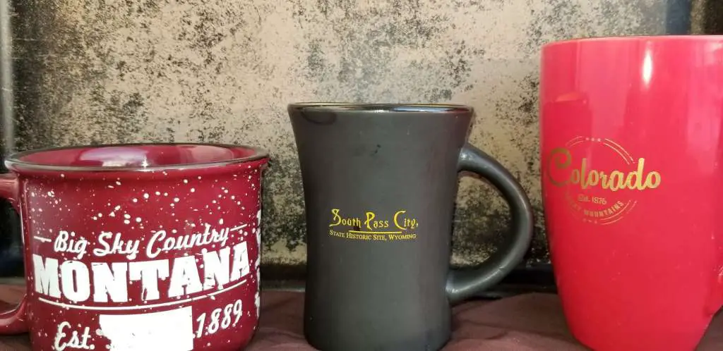 Souvenir coffee mugs displayed in natural light. Montana, South Pass City, Colorado.