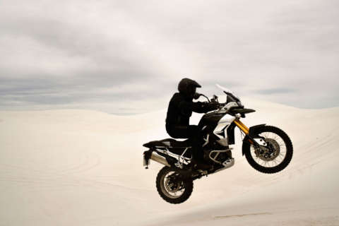 The view from the cockpit of a motorcycle. A cell phone mounted to the bars shows an incoming call.