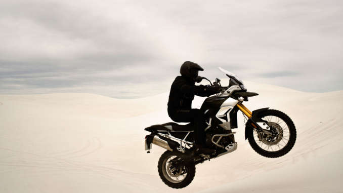 The view from the cockpit of a motorcycle. A cell phone mounted to the bars shows an incoming call.