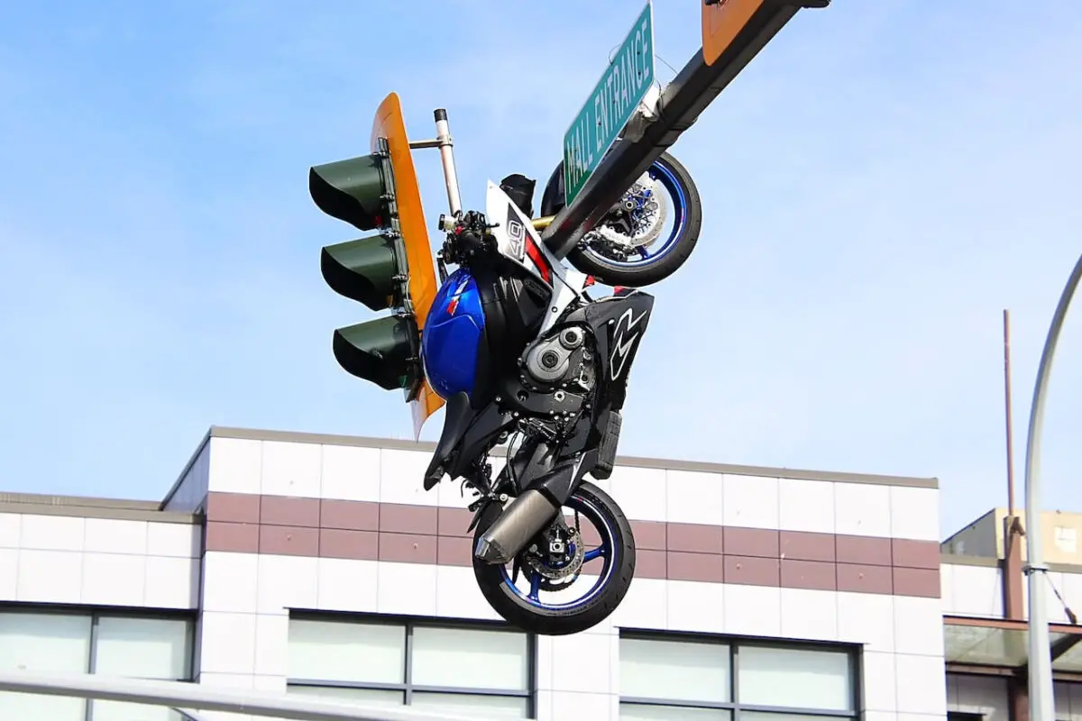 Photos show the motorcycle suspended above the roadway from an overhead traffic signal pole following the crash.