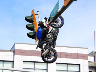 Photos show the motorcycle suspended above the roadway from an overhead traffic signal pole following the crash.