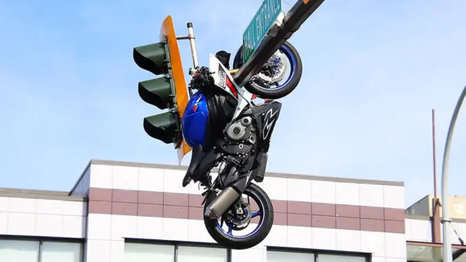 Photos show the motorcycle suspended above the roadway from an overhead traffic signal pole following the crash.